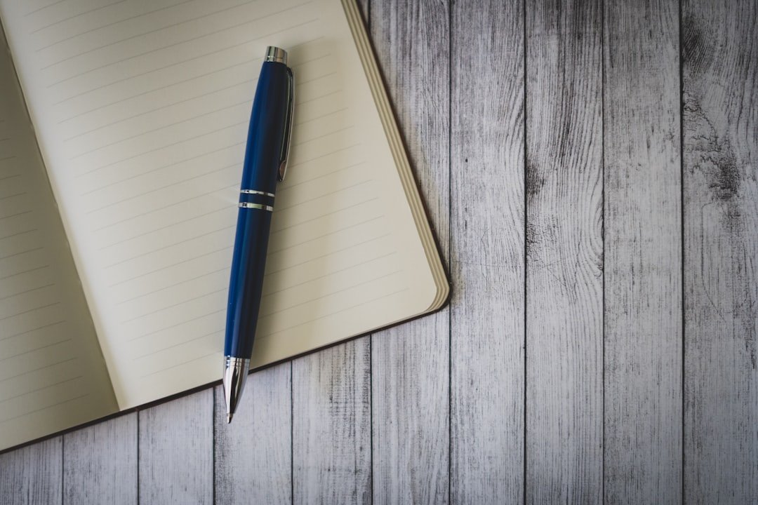 Carnet ouvert et stylo sur une table en bois.