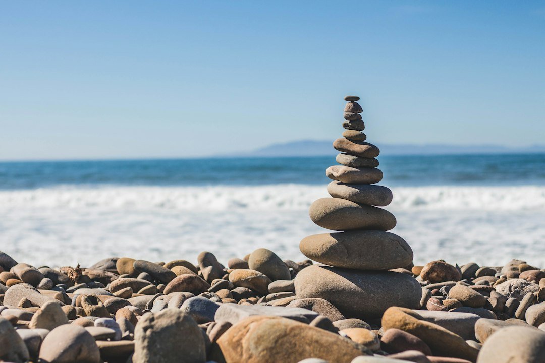 Galets en équilibre sur une plage face à la mer.